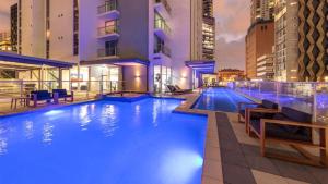 a large swimming pool in a city at night at Phenomenal City View Central Location 2BD Apart in Brisbane