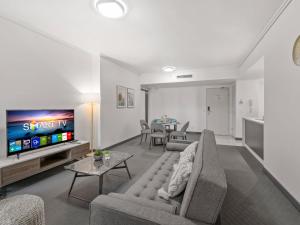 a living room with a couch and a tv at City Centre Apartment New Furnitures in Brisbane