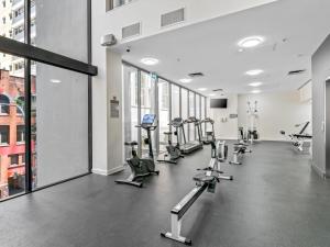 a gym with rows of treadmills and machines at City Centre 3BR Apartment with Stunning Views in Brisbane