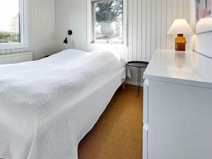 biała sypialnia z białym łóżkiem i oknem w obiekcie Holiday home Karrebæksminde IX w mieście Karrebæksminde