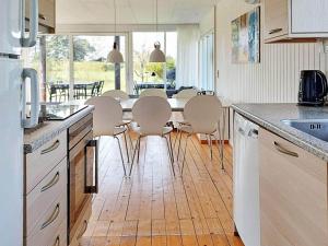 uma cozinha com uma mesa e cadeiras numa cozinha em Holiday home Karrebæksminde IX em Karrebæksminde