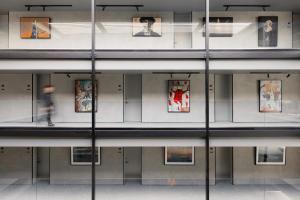 a person walking in a building with paintings on the wall at Ebb-Dunedin in Dunedin