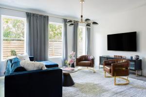 een woonkamer met een bank en stoelen en een tv bij The Adelaide - Downtown Luxury & Charming Rooftop in Nashville