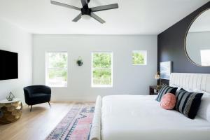 a bedroom with a white bed and a ceiling fan at The Adelaide - Downtown Luxury & Charming Rooftop in Nashville