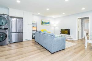 uma sala de estar com um sofá azul e uma cozinha em Newly Remodeled 2B2B Apartment in Altadena em Pasadena