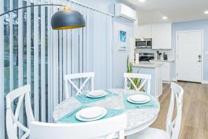 uma sala de jantar com uma mesa e cadeiras brancas em Newly Remodeled 2B2B Apartment in Altadena em Pasadena