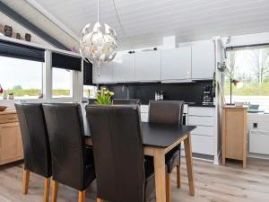 a kitchen with a black dining room table and chairs at Holiday home Aabenraa LXXI in Aabenraa