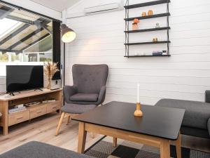 a living room with a table and a chair and a tv at Holiday home Aabenraa LXXI in Aabenraa