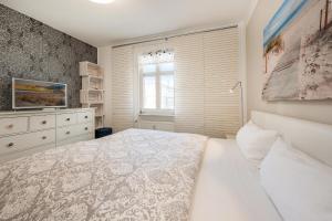 a white bedroom with a bed and a window at Haus Miramar 09 in Ahlbeck