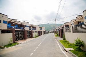 een lege straat met huizen aan weerszijden bij OG Residence in Accra