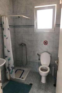a bathroom with a toilet and a shower with a window at Royal St.Georges in Fánai