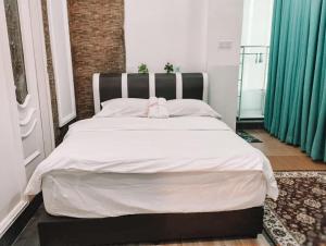 哥打巴魯的住宿－Inap Idaman 4 Near Hospital HUSM Kubang Kerian，一间卧室配有一张大床,上面有粉红色的弓