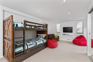 a bedroom with bunk beds and a living room at Otway Rest in Lorne