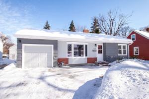 a house with a garage in the snow at NEW Charming Home in the Heart of North Fargo in Fargo