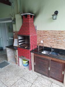 a kitchen with a brick oven with a sink at Sonho 2 Guest House in Búzios
