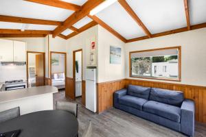 ein Wohnzimmer mit einem blauen Sofa und einer Küche in der Unterkunft Breeze Holiday Parks - Grampians in Halls Gap