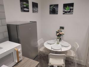 a kitchen with a white table with chairs and a refrigerator at Amazing 2 bed London apartment in London +6 photos