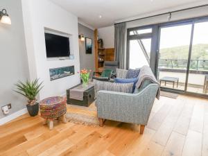 a living room with two chairs and a tv at The Crows Nest in Falmouth