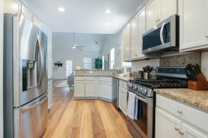 una cocina con armarios blancos y electrodomésticos de acero inoxidable en The Jade Park Circle Mins to Dwtn and Beaches, en Charleston