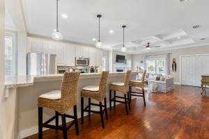 a kitchen and living room with a bar and chairs at Fullerwood Delight- Mins to Beach and Downtown in St. Augustine
