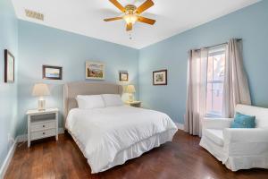 a bedroom with a white bed and a white chair at Fullerwood Delight- Mins to Beach and Downtown in St. Augustine