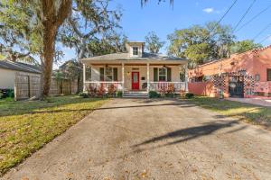 a house with a red door on a driveway at Fullerwood Delight- Mins to Beach and Downtown in St. Augustine