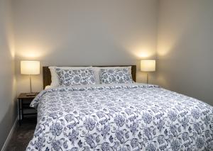 um quarto com uma cama azul e branca com 2 candeeiros em The Jade Place em Airdrie