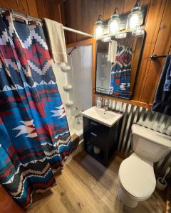 La salle de bains est pourvue de toilettes, d'un lavabo et d'un rideau de douche. dans l'établissement Three Bears Lodge, à Red River