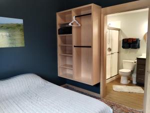 a bedroom with a bed and a bathroom with a toilet at Dockside Cabin - Homer Seaplane Base in Homer
