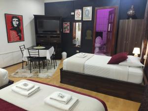 a bedroom with two beds and a table with a dining room at Hotel el Che No apto para corruptos in Azogues