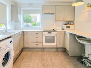 uma cozinha com electrodomésticos brancos e uma janela em The Hollies em Weston-super-Mare