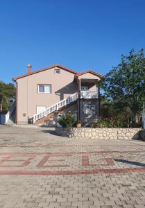 a house with a stone driveway in front of it at Apartments Zeljka B in Mundanije