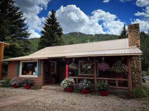 un pequeño edificio con macetas delante de él en Three Bears Lodge en Red River