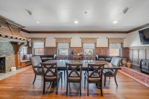 a dining room with a table and chairs and a fireplace at THE GRANDEUR ESTATE in Greensburg