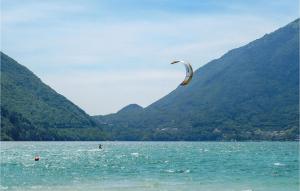 una persona que practica kitesurf en el agua con montañas en Lovely Home In Pieve Di Soligo With Wifi, en Pieve di Soligo
