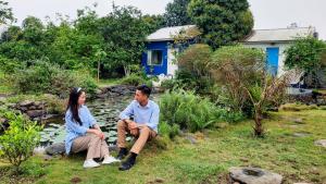 um homem e uma mulher sentados num banco num jardim em Fefe garden em Ba Vì