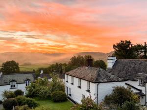 a group of houses in a village at sunset at Beech House in Sydenham Damerel