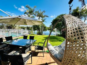 a patio with a table and chairs and an umbrella at Panarama Waterview! Waterfront Luxury Holiday Heave in GC in Gold Coast