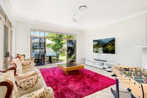 a living room with a pink rug and a tv at Panarama Waterview! Waterfront Luxury Holiday Heave in GC in Gold Coast