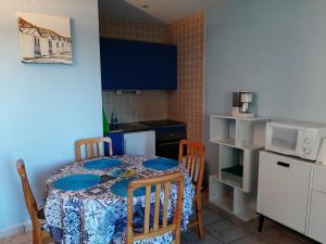 a small kitchen with a table and chairs and a microwave at Appartement Seignosse, 1 pièce, 4 personnes - FR-1-239-400 in Seignosse