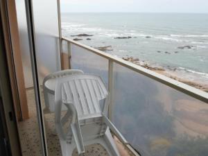 a white chair sitting on a balcony looking at the ocean at Appartement Les Sables-d'Olonne, 3 pièces, 6 personnes - FR-1-197-185 in Les Sables-d'Olonne