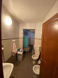 a small bathroom with two toilets and a sink at Mollys apartment 1 in Pogradec