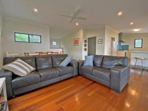 un soggiorno con divano in pelle marrone e pavimenti in legno di ANNIES HOUSE ad Amity Point