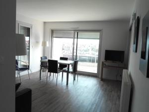 sala de estar con mesa, sillas y TV en Appartement Les Sables-d'Olonne, 2 pièces, 4 personnes - FR-1-331-77, en Les Sables-dʼOlonne