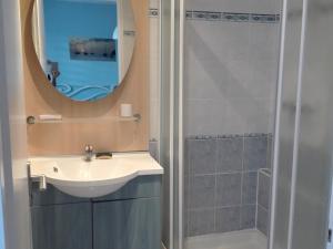 ein Bad mit einem Waschbecken und einer Dusche mit einem Spiegel in der Unterkunft Appartement Les Sables-d'Olonne, 2 pièces, 4 personnes - FR-1-331-84 in Les Sables-dʼOlonne