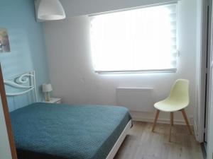 a bedroom with a bed and a chair and a window at Appartement Les Sables-d'Olonne, 2 pièces, 4 personnes - FR-1-331-84 in Les Sables-d'Olonne