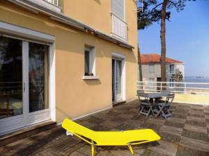 a yellow chair on a patio with a table at Appartement Saint-Brevin-les-Pins, 3 pièces, 4 personnes - FR-1-364-47 in Saint-Brevin-les-Pins