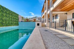 a swimming pool next to a house at Muna Tamarindo in Tamarindo