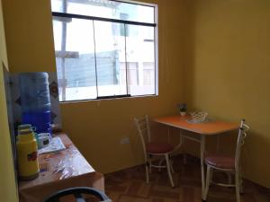 a room with a table and a window and a table and chairs at Villa Sol Host family in Tacna