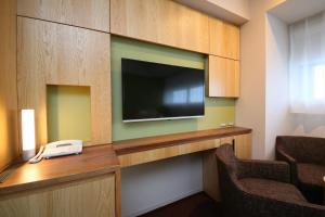 a room with a flat screen tv and a telephone at Hotel Gracery Shinjuku in Tokyo